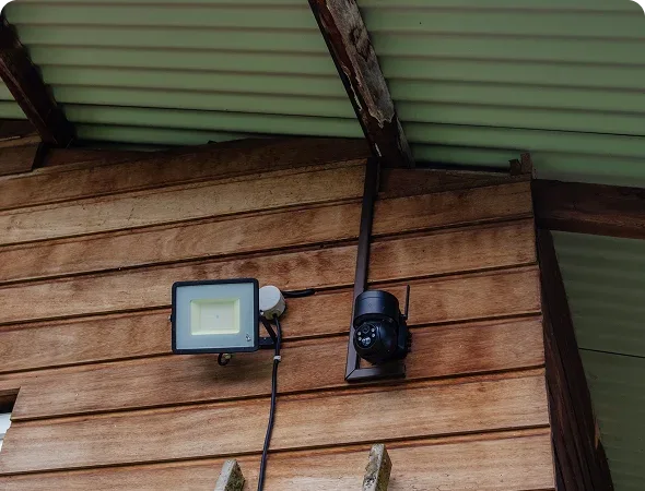 Caméra de surveillance et projecteur LED installés sur la façade d’une maison en Guyane